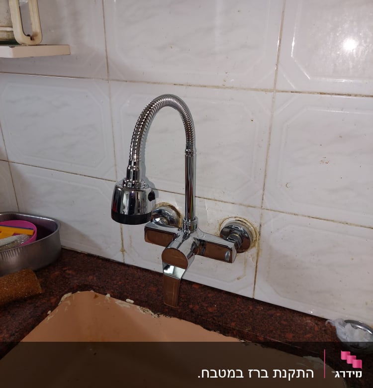 ברז מטבח עם צינור גמיש מעל כיור